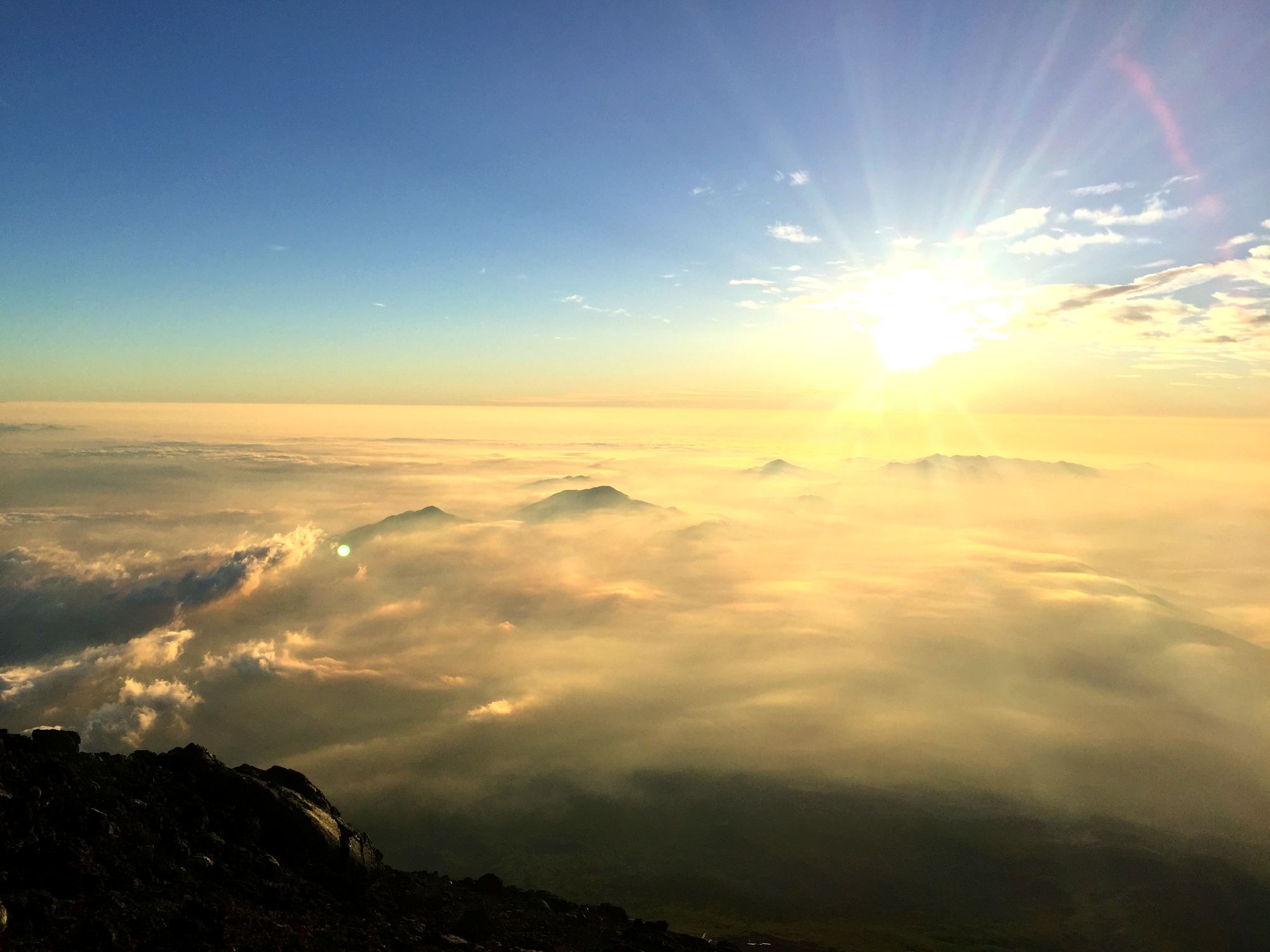Sunrise above the clouds from the summit of Mount Fuji