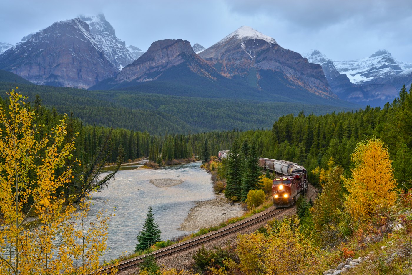 A train winding through the Canadian Rockies in autumn