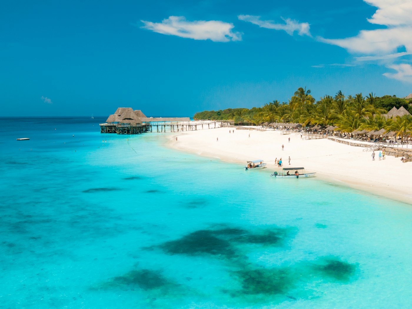 A white-sand beach and jetty on turquoise water in Zanzibar