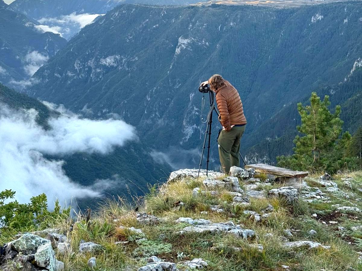 A walker on a ridge above a valley filled with cloud