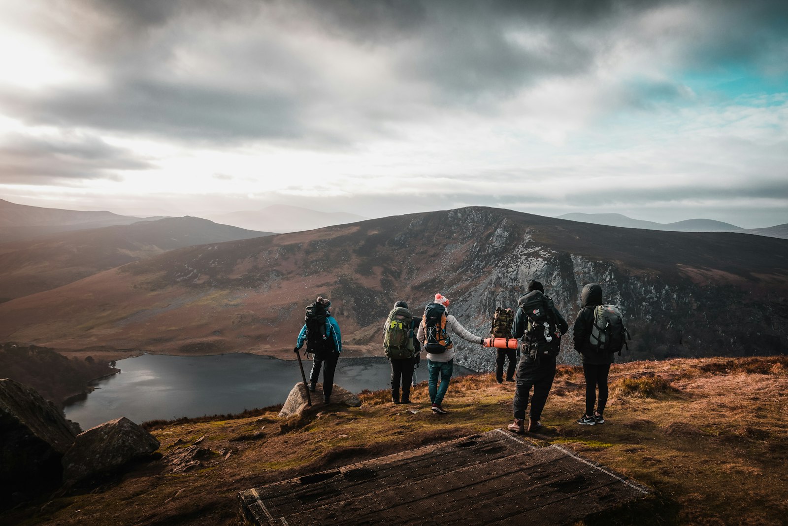 A group of walkers looking out over mountains and a lake