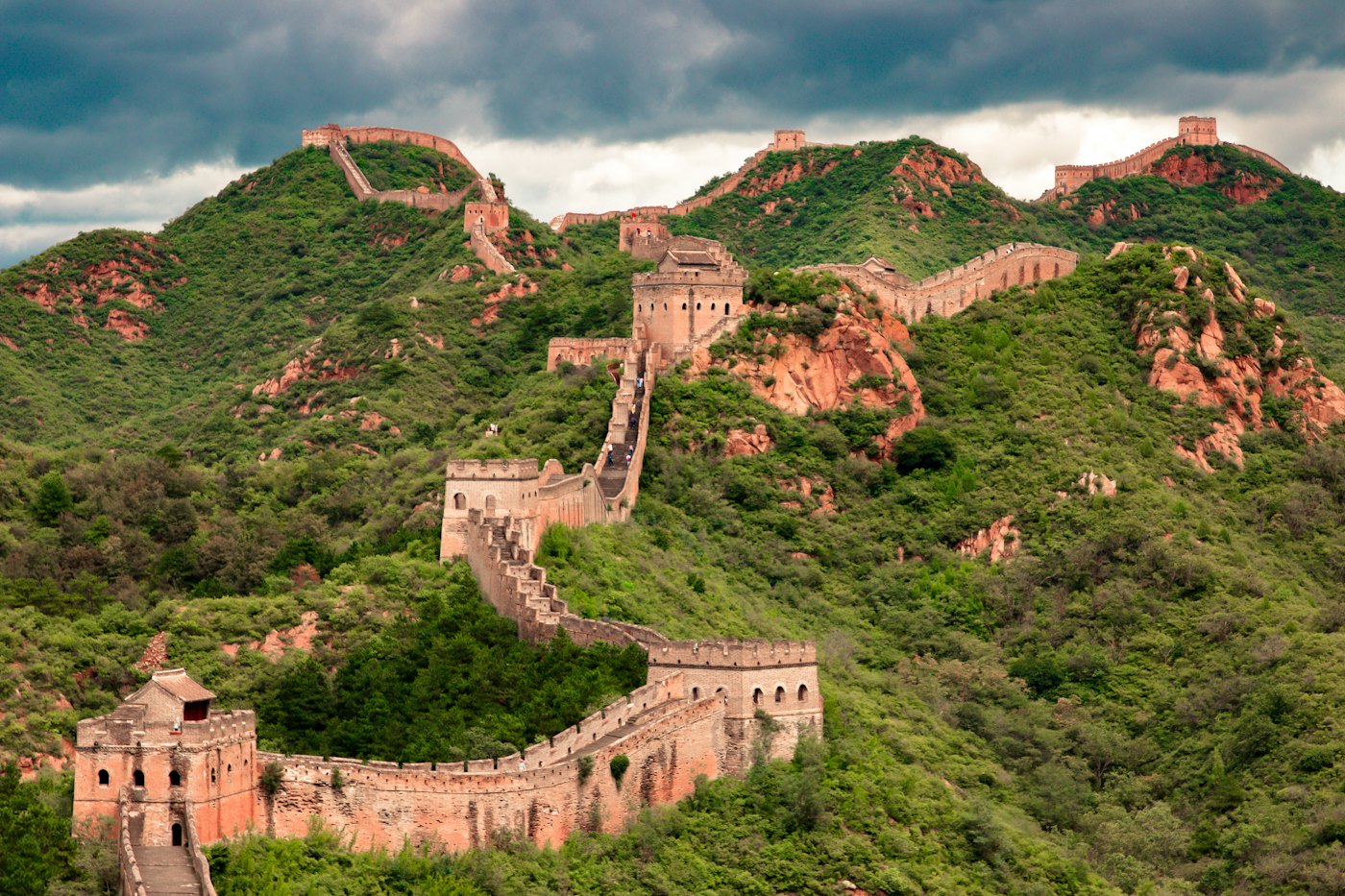 The Great Wall of China winding over green mountain ridges